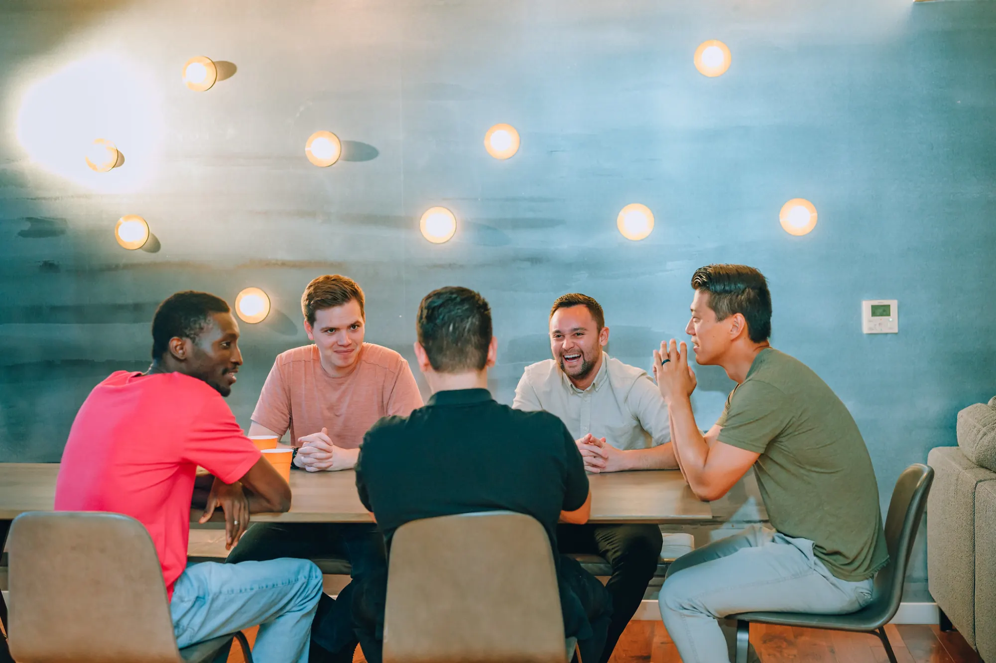 Men's dinner group in conversation around a table
